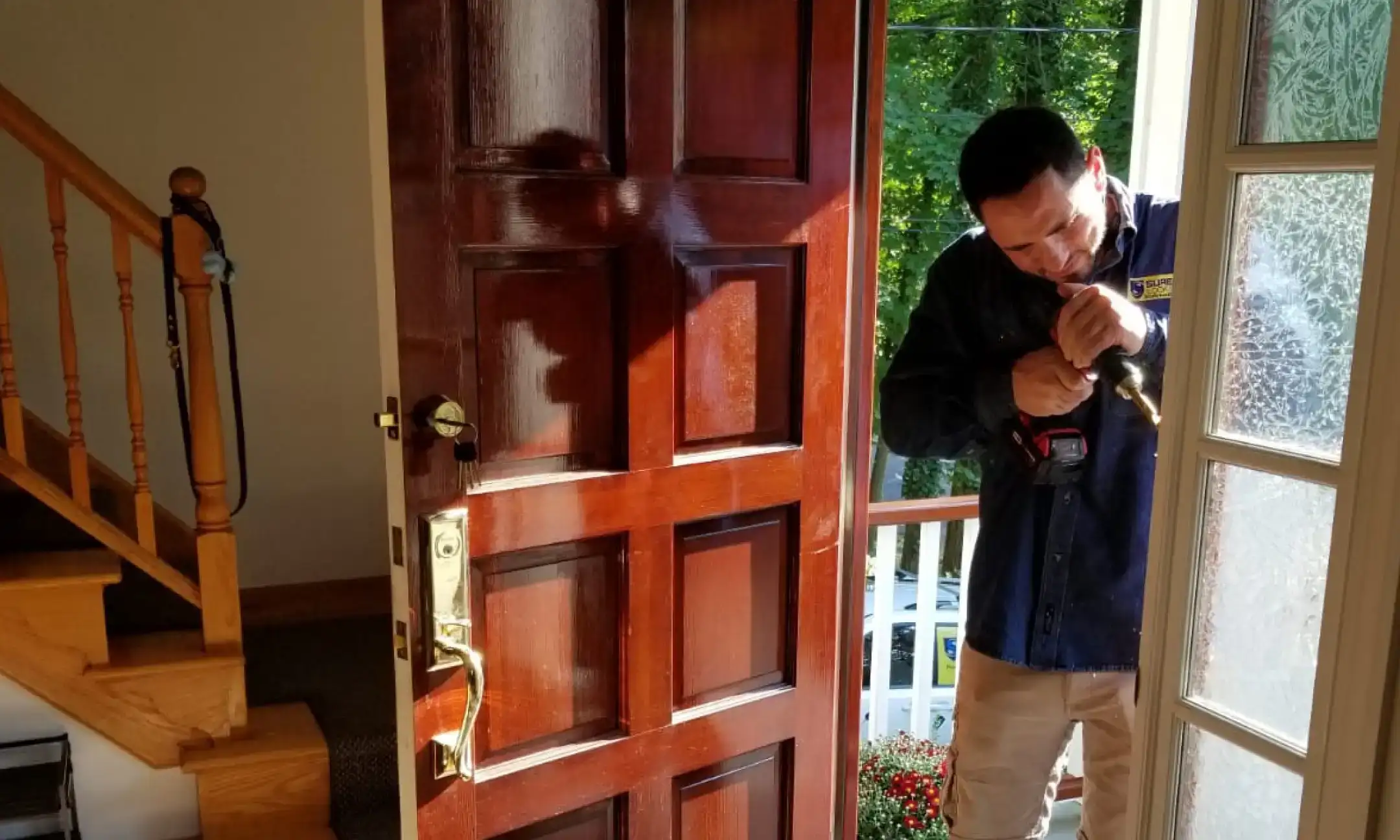 A Sure Lock & Key technician professionally installing a new lock on a residential door.