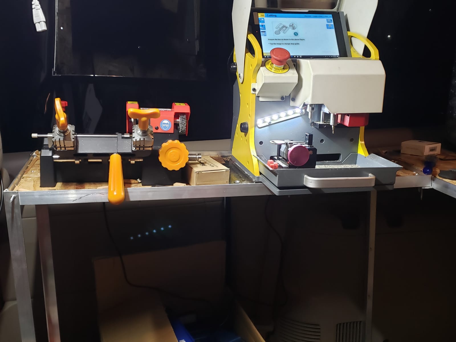 A close-up of a precision laser key cutting machine creating a new car key.