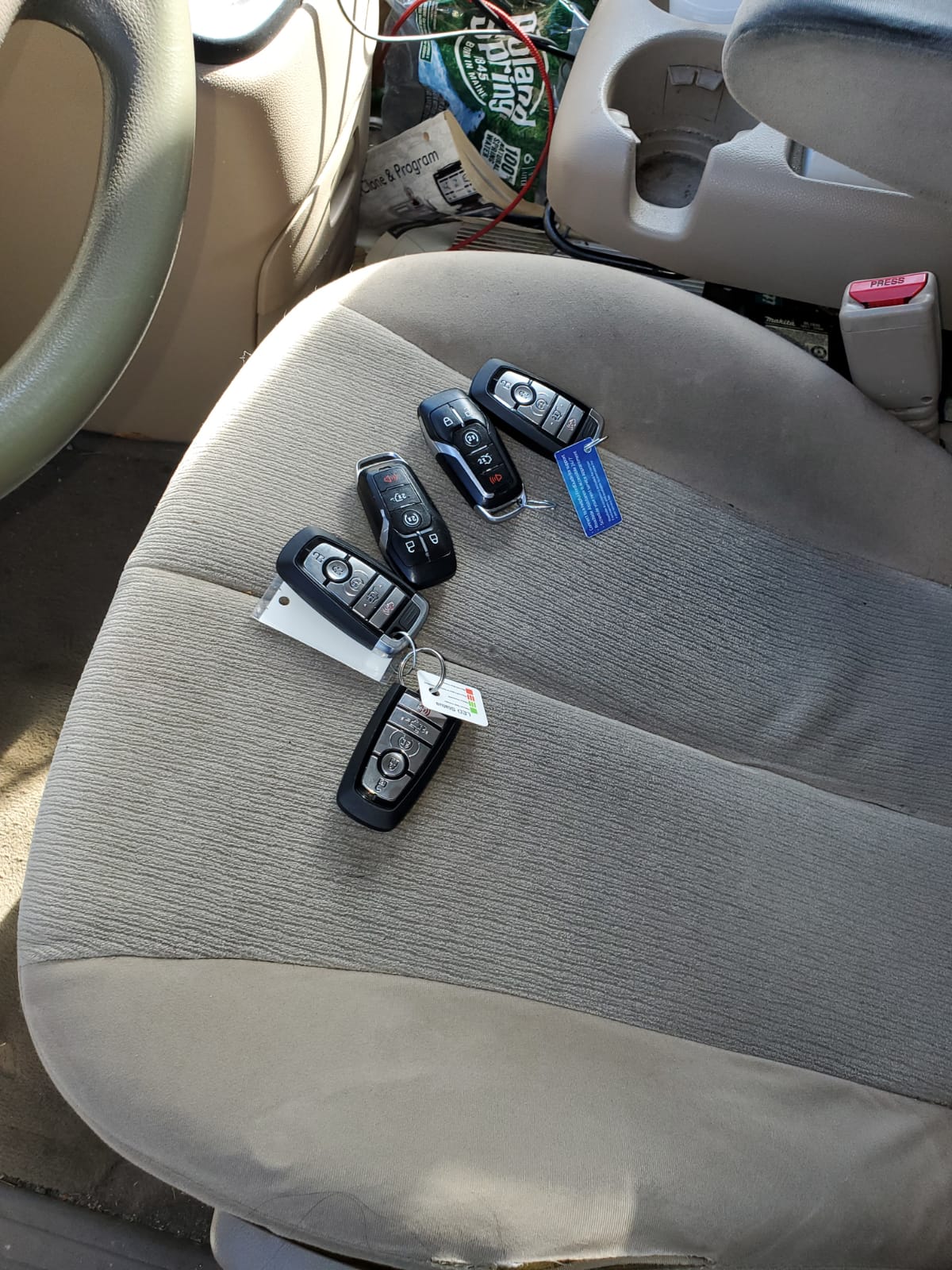 A locksmith technician programming a new car key fob with a diagnostic tool.