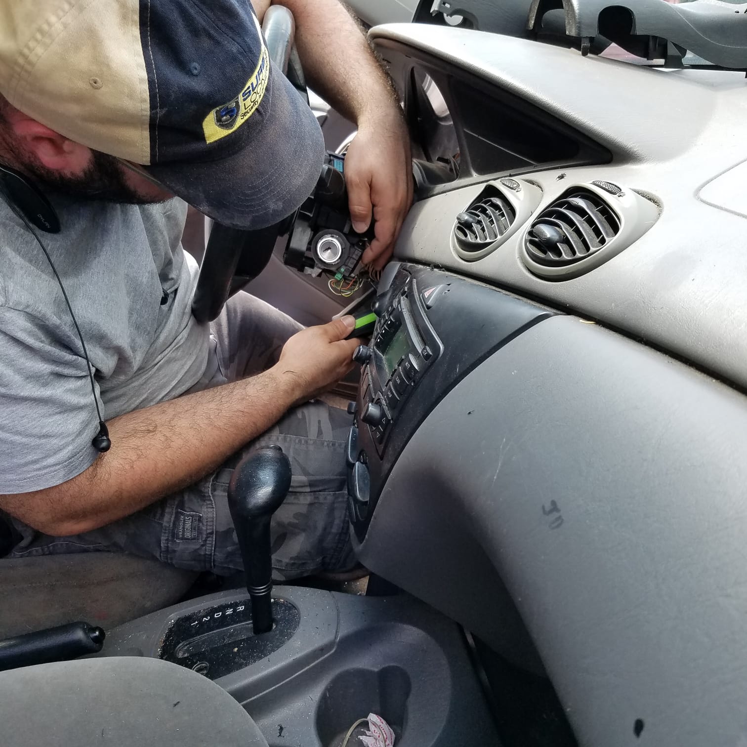 A close-up of a precision laser key cutting machine creating a new car key.